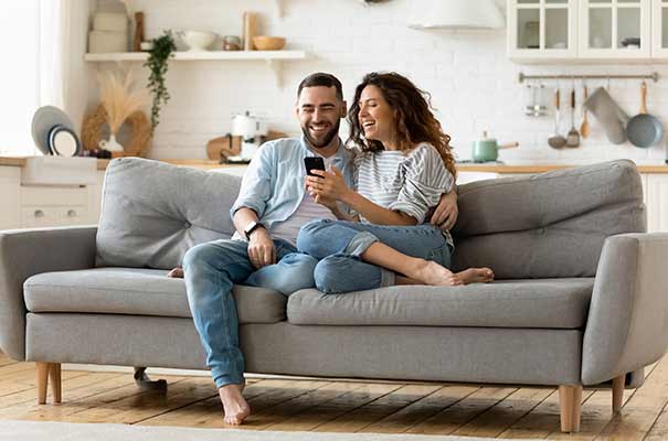Foto eines glücklicken Paares auf der Couch in ihren eigenen 4 Wänden